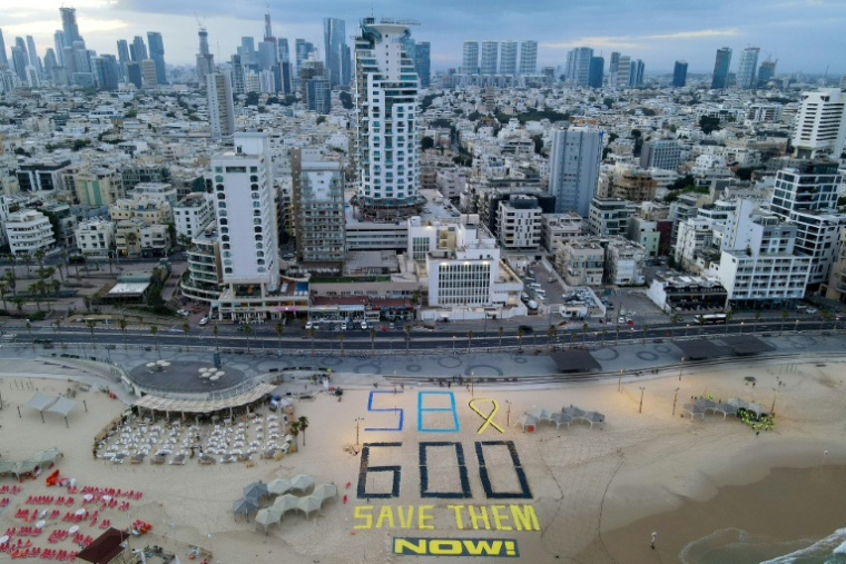 Inscription sur la plage de Tel-Aviv pour marquer le 600e jour de guerre dans la bande de Gaza et réclamer le retour des otages encore détenus, le 28 mai 2025 ( AFP / Jack GUEZ )