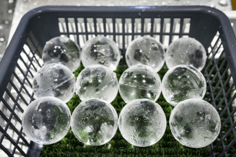 Des glaçons en forme de sphères produits à l'usine Kuramoto Ice, le 15 juin 2026 à Kanazawa, au Japon ( AFP / Yuichi YAMAZAKI )
