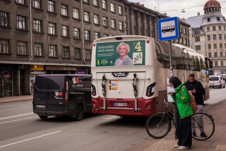 Daiga Mierina, membre de l'Union des verts et des paysans et actuelle présidente du Parlement, sur une affiche électorale à l'arrière d'un bus, le 30 septembre 2026 à Riga, en Lettonie ( AFP / Gints Ivuskans )
