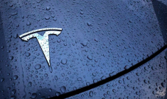 Le logo d'un véhicule électrique Tesla est placé sur une voiture à l'extérieur d'un concessionnaire à Drogenbos