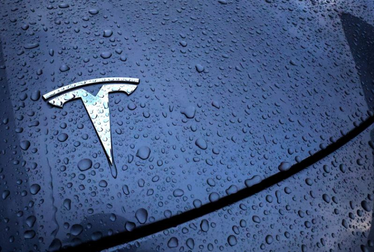 Le logo d'un véhicule électrique Tesla est placé sur une voiture à l'extérieur d'un concessionnaire à Drogenbos