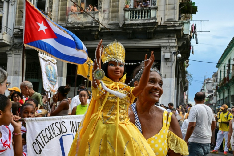 Une fidèle brandit une poupée représentant la Vierge de la Charité, dans la religion catholique, et Oshun dans la religion yoruba, lors de la traditionnelle procession en leur honneur, à La Havane, le 8 septembre 2026 ( AFP / YAMIL LAGE )