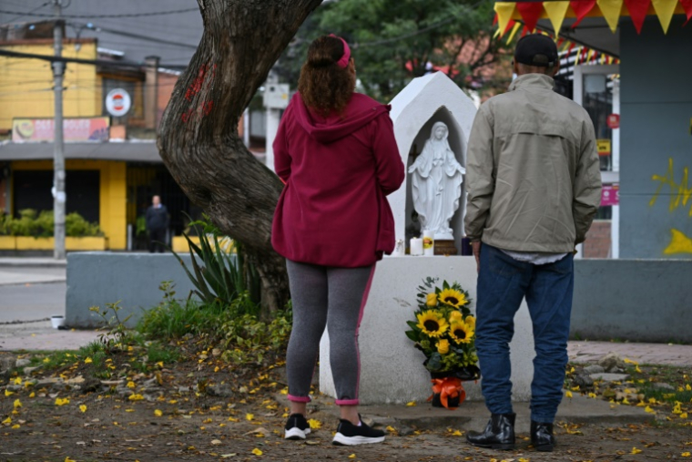 Des personnes venues se recueuillir à l'endroit où le candidat présidentiel colombien Miguel Uribe a été mortellement blessé dans le quartier Modelia de Bogota, le 11 août 2025 ( AFP / Raul ARBOLEDA )