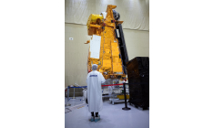 Un employé d'Airbus se tient devant le satellite météorologique MetOp-SG B (Meteorological Operational Satellite - Second Generation) dans la salle blanche de la branche défense et espace de l'entreprise, le 10 novembre 2023 à Toulouse. ( AFP / LIONEL BONAVENTURE )