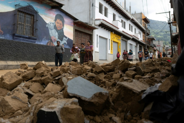 Des habitants passent devant le mur effondré d'une maison lors d'une série de tremblements de terre à Santa Maria de Jesus, au Guatemala, le 9 juillet 2025 ( AFP / Edwin Bercian )