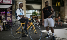 Deux livreurs à vélo se reposent pendant une vague de chaleur estivale près des restaurants en attendant des commandes, à Bordeaux, le 7 juillet 2026 ( AFP / Philippe LOPEZ )