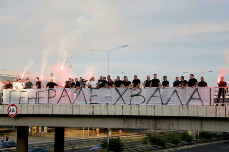 Des personnes rassemblées sur une passerelle d'autoroute tiennent une banderole "Merci, Général", avant le passage du convoi transportant la dépouille du criminel de guerre serbe de Bosnie Ratko Mladić à Belgrade, en Serbie, le 3 septembre 2026 ( AFP / Pedja MILOSAVLJEVIC )