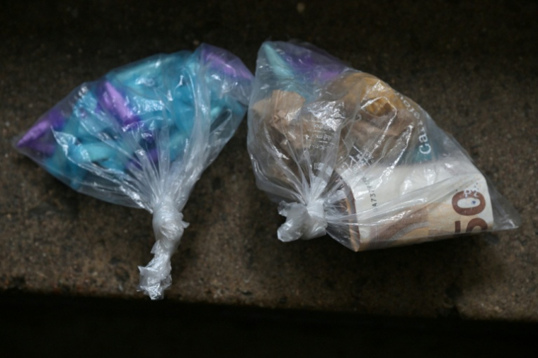 Cette photographie montre des sacs en plastique saisis contenant du cabanis, de la cocaïne et de l'argent lors d'une opération de sécurité dans un immeuble d'un quartier de Nantes, le 17 décembre 2025 ( AFP / Damien MEYER )