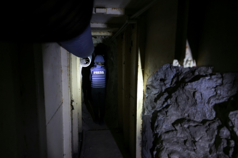 Un journaliste dans un tunnel abandonné, supposément utilisé par le Hezbollah, au fond d'une vallée à Zebqine, lors d'une visite de presse organisée par l'armée libanaise, le 28 novembre 2025 dans le sud du Liban ( AFP / ANWAR AMRO )