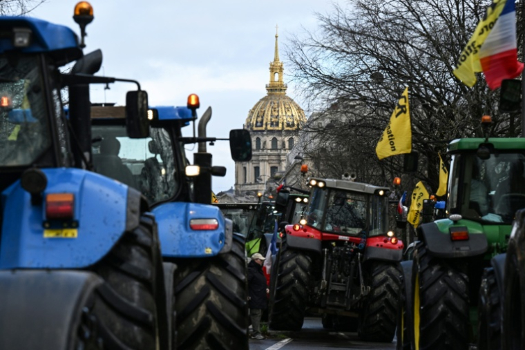 Des agriculteurs français conduisent des tracteurs lors d'une manifestation organisée par le syndicat agricole Coordination Rurale, avec en arrière-plan le dôme de l'Hôtel des Invalides, dans l'ouest de Paris, le 23 février 2024 ( AFP / MIGUEL MEDINA )