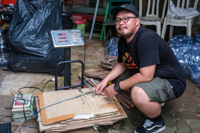 Wahyu Eka Styawan de l'ONG WALHI, devant un centre de collecte qui rachète les matériaux recyclables, le 4 février 2026 à Jakarta, en Indonésie ( AFP / BAY ISMOYO )