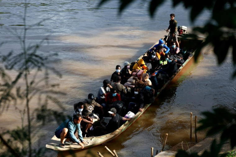 Des personnes de différents pays, qui travaillaient au complexe du parc KK en Birmanie, traversent en bateau la rivière Moei pour se rendre en Thaïlande, le 24 octobre 2025 ( THAI NEWS PIX / Sarot Meksophawannakul )