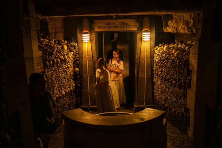 Des touristes visitent les Catacombes de Paris, le 12 août 2025 ( AFP / Dimitar DILKOFF )