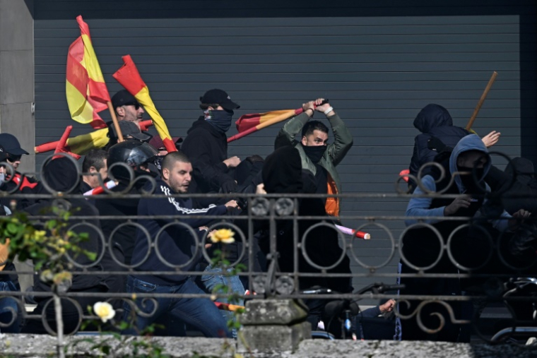 Des partisans de La Phalange (extrême droite)  affrontent des contre-manifestants antifascistes (à droite) lors d'un rassemblement appelé par la Phalange pour l'unité de l'Espagne et marquant la fête nationale espagnole à Vitoria le 12 octobre 2025. ( AFP / ANDER GILLENEA )
