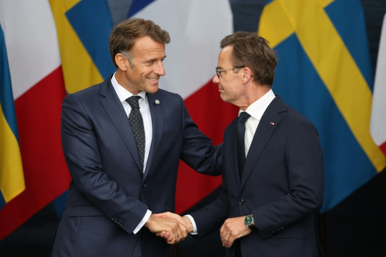 Le président français et le Premier ministre suédois Ulf Kristersson se serrent la main après la signature d'un contrat portant sur l'acquisition par la Suède de quatre frégates françaises, le 31 août 2026 à Stockholm ( AFP / Ludovic MARIN )