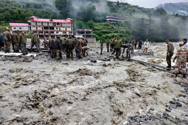 Cette photographie, diffusée le 6 août 2025 par l'armée indienne, montre des agents de sécurité et de secours soulevant des pierres et des débris pour construire un passage, au lendemain d'une violente averse qui a provoqué une coulée de boue massive et des crues soudaines dans l'État indien de l'Uttarakhand ( Indian Army / - )
