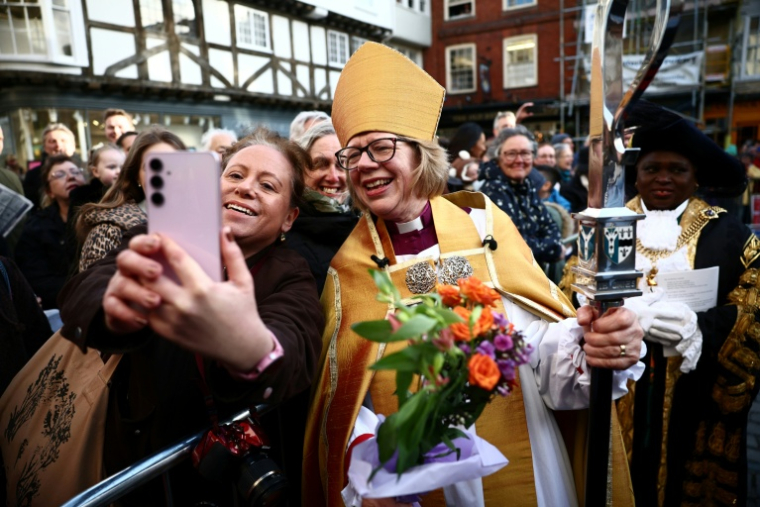 La nouvelle archevêque de Canterbury, Sarah Mullally, pose pour une photo avec une fidèle à Buttermarket après sa cérémonie d'intronisation à la cathédrale de Canterbury, dans le sud-est de l'Angleterre, le 25 mars 2026 ( AFP / Henry Nicholls )