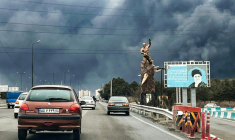 Des véhicules roulent en direction d'un épais mur de fumée à Téhéran, cible de frappes aériennes israélo-américaines, le 8 mars 2026  ( AFP / - )