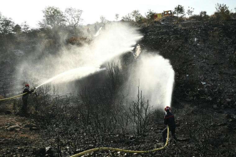 Des pompiers tentent d'éteindre les braises du gigantesque incendie dans l'Aude, le 9 août 2025 à Albas ( AFP / Bertrand GUAY )