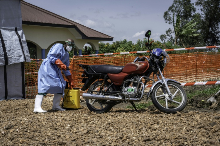 Dieudonné Sezabo, un agent de santé, décontamine une moto ayant servi à transporter une jeune femme soupçonnée d'avoir la maladie Ebola, à l'hôpital de Rwampara, dans le nord-est de la République démocratique du Congo (RDC) le 26 mai 2026 ( AFP / Glody MURHABAZI )