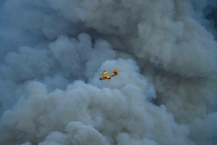 Un Canadair au-dessus des fumées d'un important incendie dans l'Aude, le 5 août 2025 ( AFP / Idriss BIGOU-GILLES )