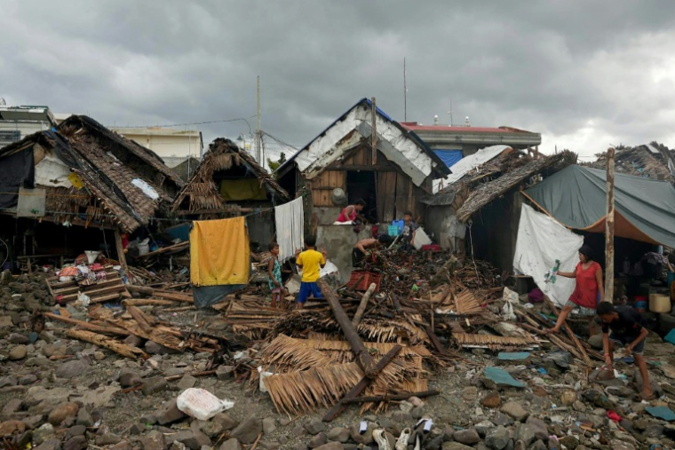 Des habitants devant leurs maisons détruites, à proximité de la digue de Garchitorena, dans la province de Camarines Sur, au sud de Manille, au lendemain du passage du super typhon Fung-wong, le 10 novembre 2025 aux Philippines ( AFP / Charism SAYAT )