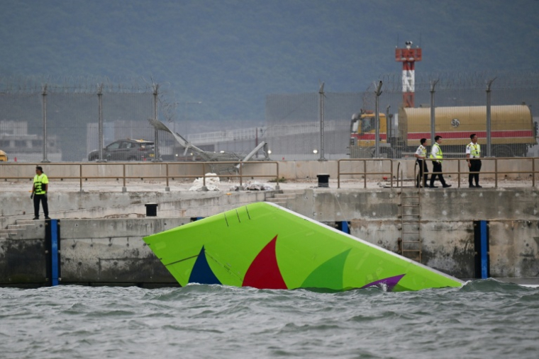 La queue d'un avion cargo Boeing dans l'eau après être sorti de piste lors de son atterrissage à l'aéroport international de Hong Kong, le 20 octobre 2025 ( AFP / Peter PARKS )