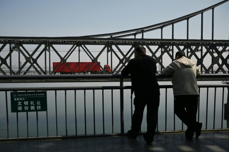 Un camion transportant des marchandises passe sur le pont de l'amitié sino-coréenne, reliant la ville frontalière chinoise de Dandong, à la ville nord-coréenne de Sinuiju, le 26 mars 2026 ( AFP / GREG BAKER )
