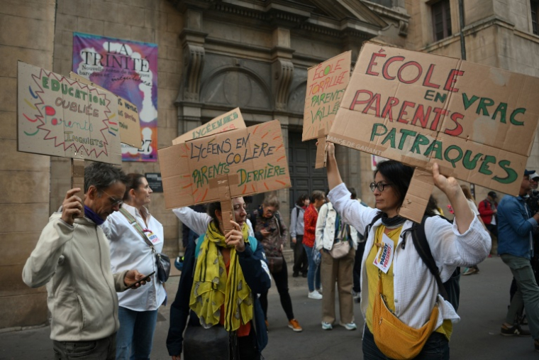 Des parents d'élèves brandissent des pancartes lors d'une manifestation devant le lycée Ampère à Lyon, le 6 octobre 2026 ( AFP / Olivier CHASSIGNOLE )