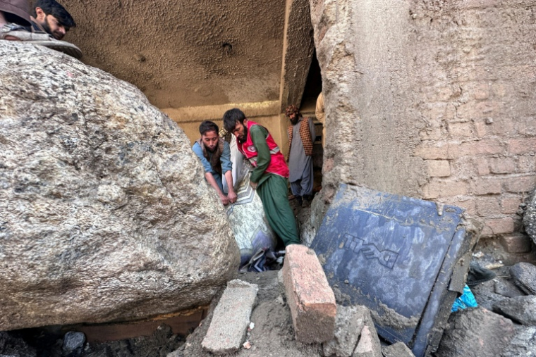 Des habitants fouillent les décombres de boutiques détruites par des crues soudaines à Parun, dans la province du Nouristan, le 21 juillet 2026 en Afghanistan ( AFP / - )
