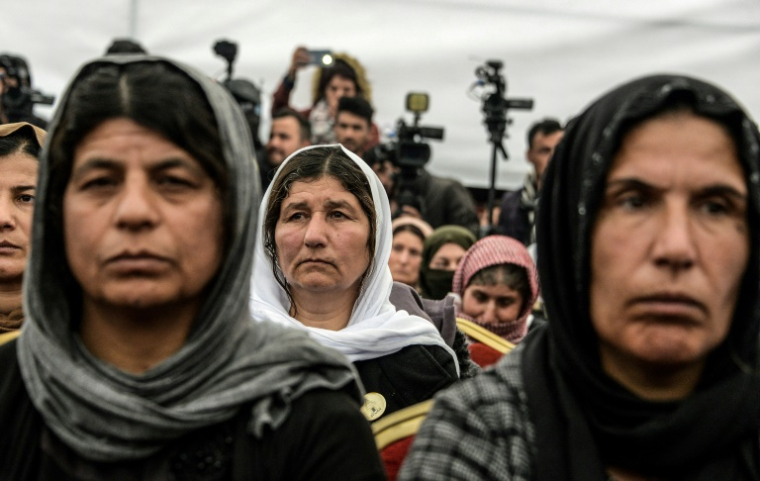 Des femmes yazidies irakiennes assistent à l'exhumation d'une tombe collective de centaines de Yazidis tués par des membrse du groupe État islamique (EI) dans le village de Kojo, dans le nord de l'Irak, le 15 mars 2019 ( AFP / Zaid AL-OBEIDI )
