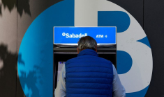 Un homme utilise un distributeur dans une agence de la banque espagnole Sabadell à Madrid