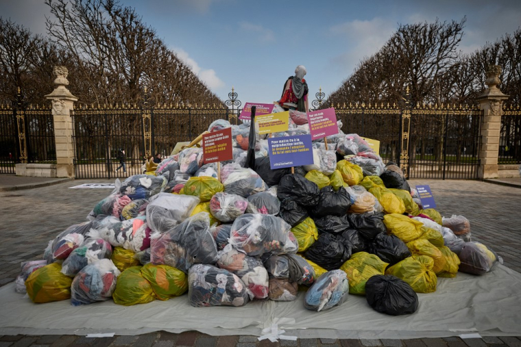 Des sacs de vêtements lors d'une manifestation contre la fast-fashion, à Paris, en mars 2024 ( AFP / KIRAN RIDLEY )