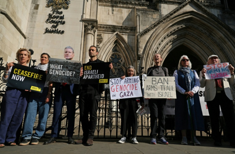Les acteurs Juliet Stevenson (G) et Khalid Abdalla (4G), avec d'autres manifestants dont un porte un masque à l'effigie du Premier ministre Keir Starmer, devant la Haute Cour de Londres avant une audience visant à stopper l'exportation de composants d'avion britanniques vers Israel le 13 mai 2025 ( AFP / Adrian Dennis )