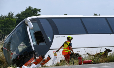 Un maître-chien du SDIS 49 intervient près d'un car qui transportait des adultes et des enfants ukrainiens avant d'avoir un accident faisant plusieurs morts sur l'A81 à Degré, en Sarthe, le 13 juin 2025 ( AFP / JEAN-FRANCOIS MONIER )