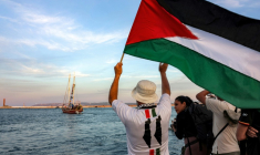 Un homme agite un drapeau palestinien à l'adresse d'activistes se trouvant dans un bateau quittant le port tunisien de Bizerte, le 14 septembre 2025 ( AFP / MOHAMED FLISS )