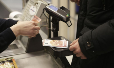 Une caissière compte des billets dans un magasin