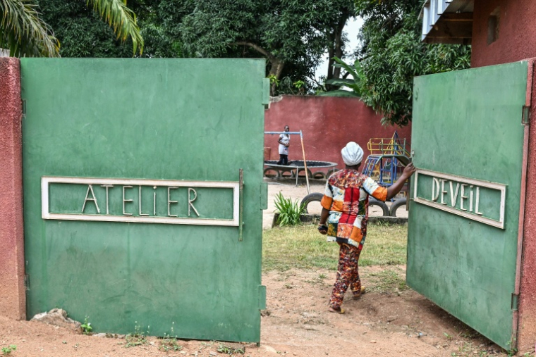Une femme ouvre le portail du centre Arche, un établissement qui assure des soins à des déficiants intellectuels, à Bouaké, en Côte d'Ivoire, le 17 septembre 2026 ( AFP / Issouf SANOGO )