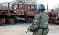 Un soldat des forces de sécurité rwandaises passe devant un camion brûlé au port de Mocimboa da Praia, au Mozambique