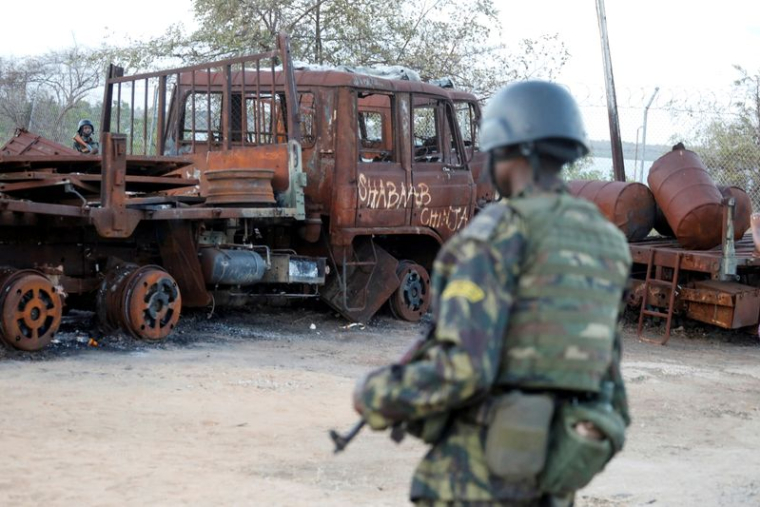 Un soldat des forces de sécurité rwandaises passe devant un camion brûlé au port de Mocimboa da Praia, au Mozambique