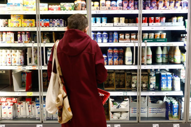 Un client regarde une étagère de produits laitiers dans un supermarché Rewe à Potsdam