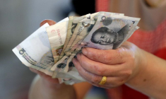 Un vendeur tient des billets de yuan chinois sur un marché de Pékin