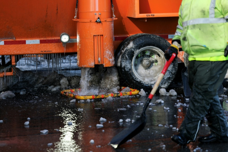 Une fondeuse à neige déverse de l'eau dans les égouts dans le quartier de Manhattan, à New York, le 29 janvier 2026 ( AFP / ANGELA WEISS )