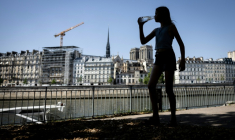 Piétonne avec une bouteille en plastique, sur la voie Georges-Pompidou, itinéraire de 13 kilomètres traversant Paris en longeant la rive droite de la Seine, le 24 juin 2026. ( AFP / Simon WOHLFAHRT )