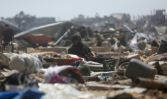 Un homme allongé sur des objets récupérés regarde les Palestiniens inspecter les tentes détruites dans un camp de déplacés improvisé suite à une incursion signalée la veille par des chars israéliens dans la zone de Khan Yunis, dans le sud de la bande de Gaza, le 11 juillet 2025. ( AFP / - )