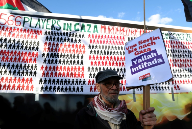 Un militant brandit une pancarte du parti de gauche radicale Die Linke avec l’inscription « De Berlin à Gaza – Yallah Intifada » lors d’une manifestation pro-palestinienne à Berlin, le 10 octobre 2026 ( AFP / Adam BERRY )