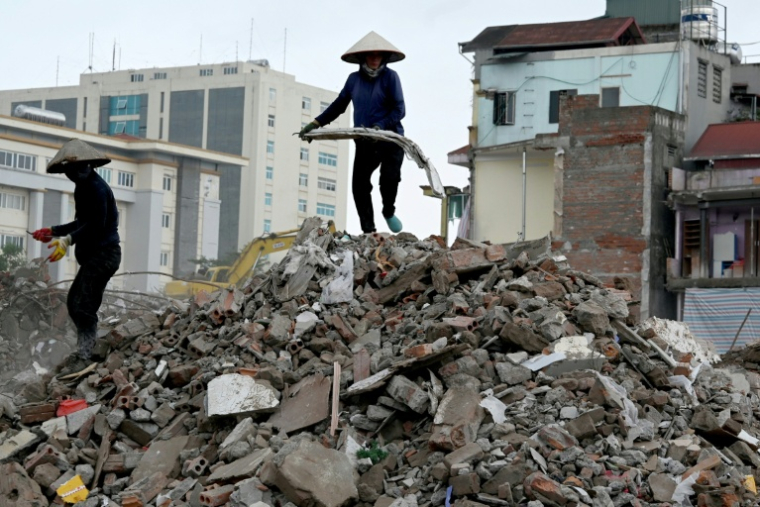 Des ouvriers récupèrent du métal sur un chantier de démolition à Hanoï, le 18 mai 2026 ( AFP / Nhac NGUYEN )
