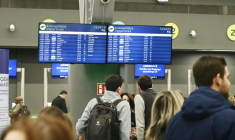 Des passagers devant un panneau d'information affichant de nombreux vols annulés, à l'aéroport de Thessalonique en Grèce le 4 janvier 2026 ( AFP / Sakis Mitrolidis )