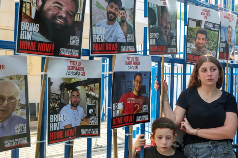 Des photos d'otages israéliens retenus à Gaza depuis le 7 octobre 2023, lors des funérailles de Jonathan Samerano, le 24 juin 2025 à Tel-Aviv ( AFP / Jack GUEZ )