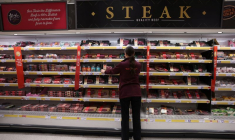 Un employé range des produits à l'intérieur d'un supermarché Sainsbury's à Londres